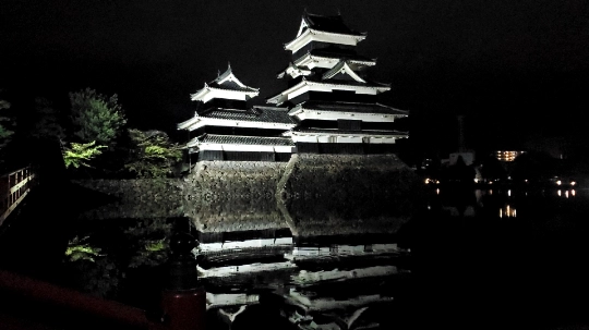 Matsumoto Castle illuminated at night reflected in the moat